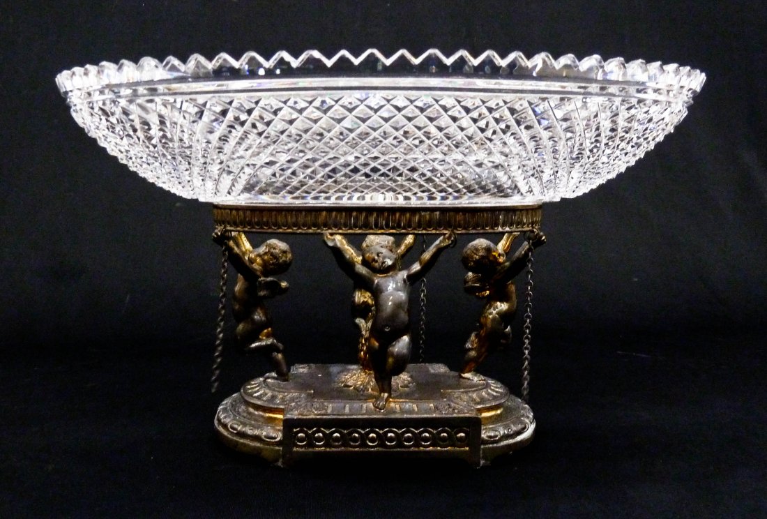 Antique Pairpoint Cut Glass Center Bowl 7.75''x13.5''.: Antique Pairpoint Cut Glass Center Bowl 7.75''x13.5''. Brilliant cut glass oval bowl with figural cherub silverplated base marked Pairpoint. A few small edge chips to bowl and wear to gilt patina.