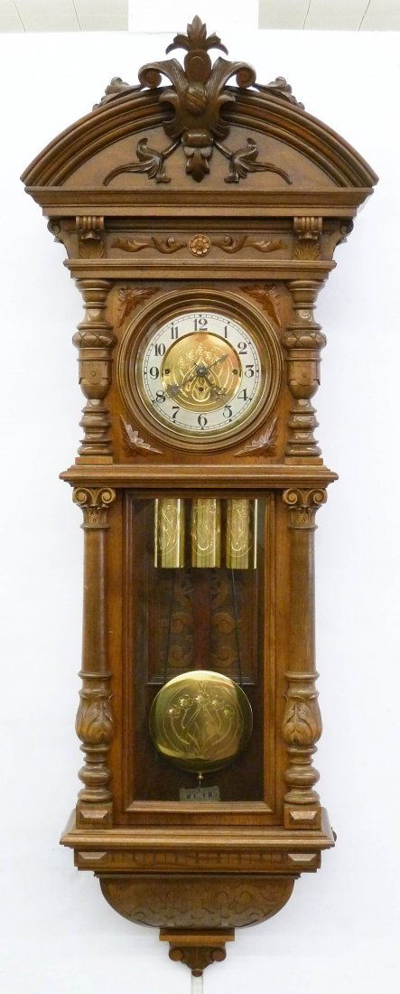 Ornate WF German Vienna Regulator Wall Clock: Ornate WF German Vienna Regulator Wall Clock 54''x19''x8.5''. Large carved walnut case. Three weight drive with two chime movement. Matching art nouveau floral dial, pendulum and weights. Working orde