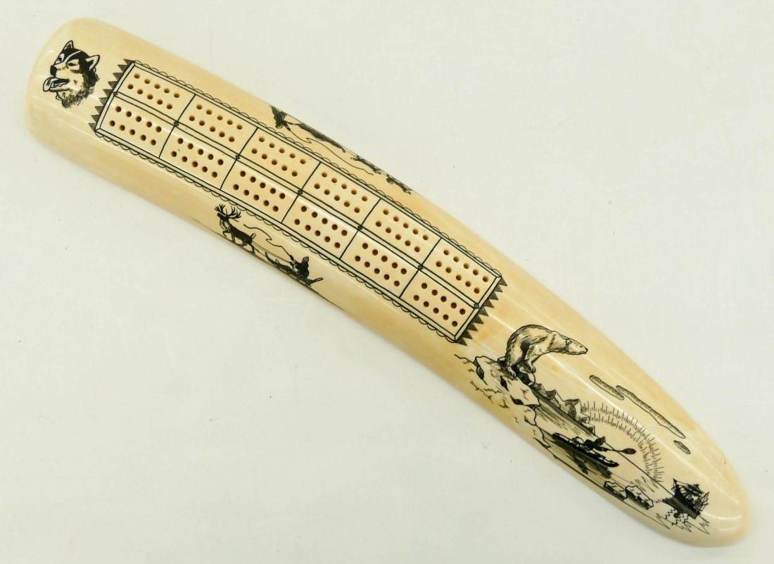 Vintage Nuguruk Alaskan Eskimo Scrimshawed Ivory: Vintage Nuguruk Alaskan Eskimo Scrimshawed Ivory Cribbage Board 14''x2.5''. An impressive large walrus tusk with dog sled and polar bear imagery. Signed on side with ''Genuine Ivory'' gold label on bo