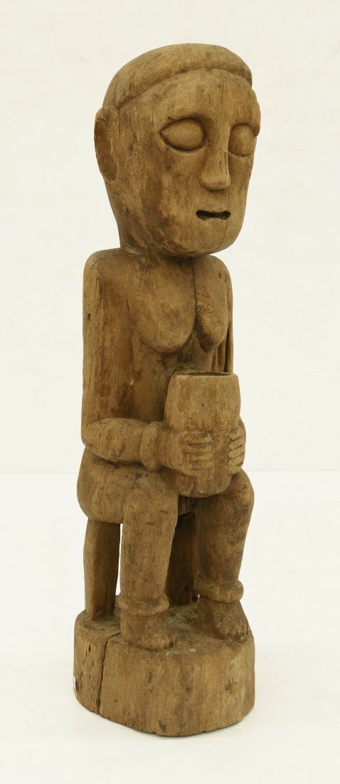 Indonesian Belu Ancestral Carved Wood Figure: Indonesian Belu Ancestral Carved Wood Figure 20''x5.5''. Seated male or female ancestor figure. Patung or Flores islands. Natural age cracking and wear. 19th or 20th century.