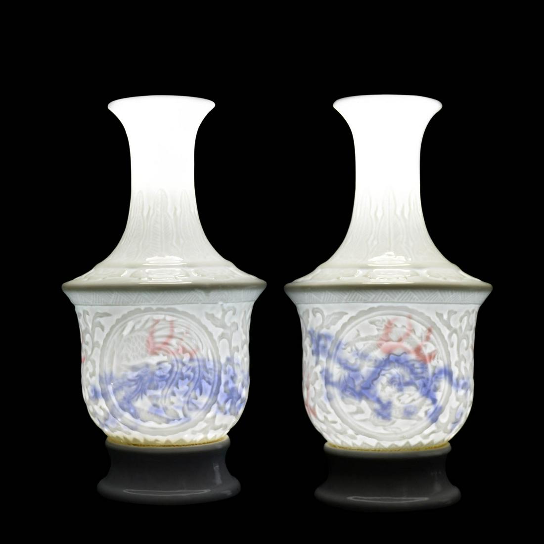 Ming Dynasty, A Pair of White-glazed Dragon and Phoenix: 明 甜白瓷印花龙凤红彩壁影内府斜肩撇口瓶一对 (官)字款 