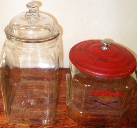Two Country Store Advertising Display Jars: Two country store advertising display jars for Planter's Peanuts and Lance Nuts. Planter's jar has several rim chips on cover. 12" tall Lance Nuts is 9" tall.