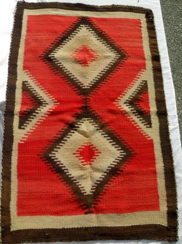 Vintage Southwest Navajo Lodge Rug: Two symmetrical diamond lozenges, red background, brown and white borders. A couple of minor breaks to wool fibers. 42" x 27"
