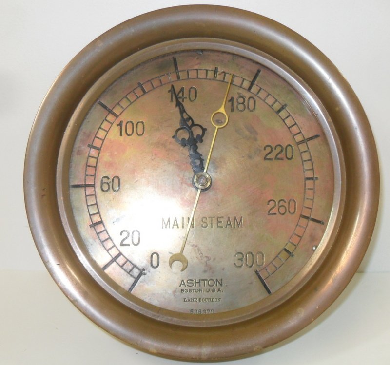 Circular Brass Steam Gauge Clock: Brass steam gauge by Ashton Co of Boston, Mass. Retro fitted with later clock movement, leaving intact original steam gauge face. Mounted on wooden backing. 10" diameter.