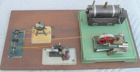 Fleischmann Steam Powered Workshop: Actual working model. Steam powered engine runs grind wheel and trip hammer mounted on wooden board. Each piece is marked. 11 1/2" x 23"