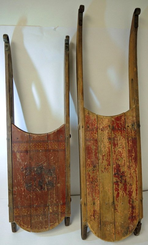 Two Early Curved Runner South Paris Sleds: Separations and paint loss to tops. Signed on underside with South Paris brand. 37" and 32" long