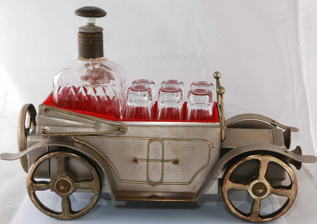 Antique Car Music Box and Liquor Display: Metal worked antique car music box is also a liquor display with glass decanter and six shot glasses. In working condition. 9.5" X 13.5"