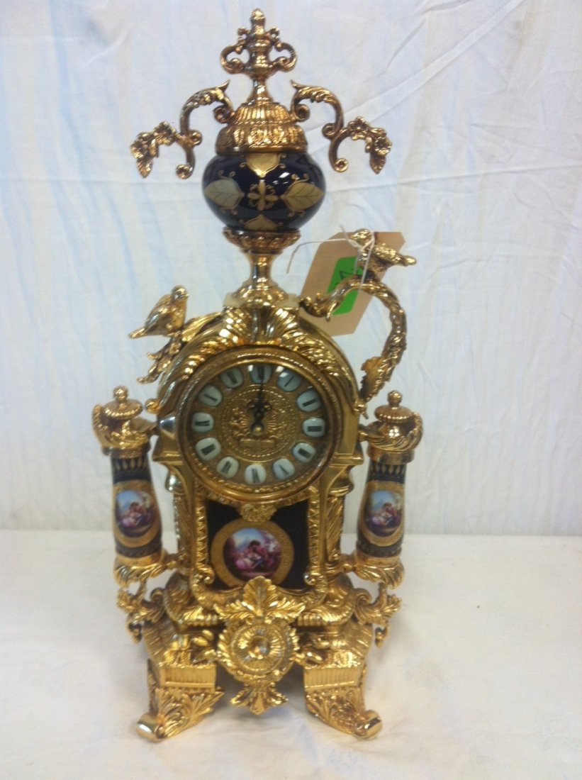 Porcelain and Brass Clock: Gold colored ornately crafted brass and porcelain clock. WIth hand painted images depicting a couple in love. 18.5" x 9".
