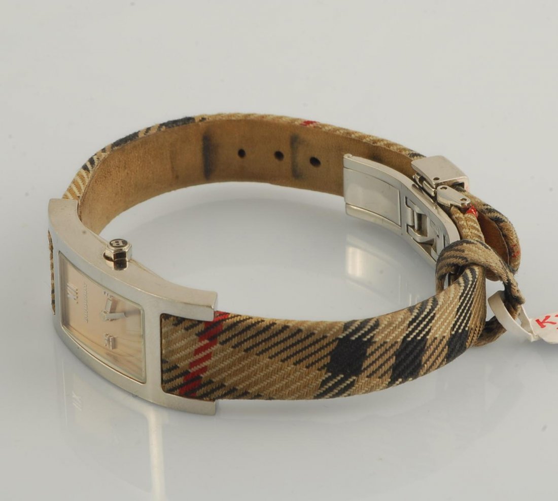 Burberry Ladies Checked Strap Watch: Stainless-steel watch with scratch-resistant mineral crystal, quartz movement and an iconic checked pattern on the strap. Deployant buckle. Band length: 228mm. Band width: 15mm. Case dimensions: 22mm 