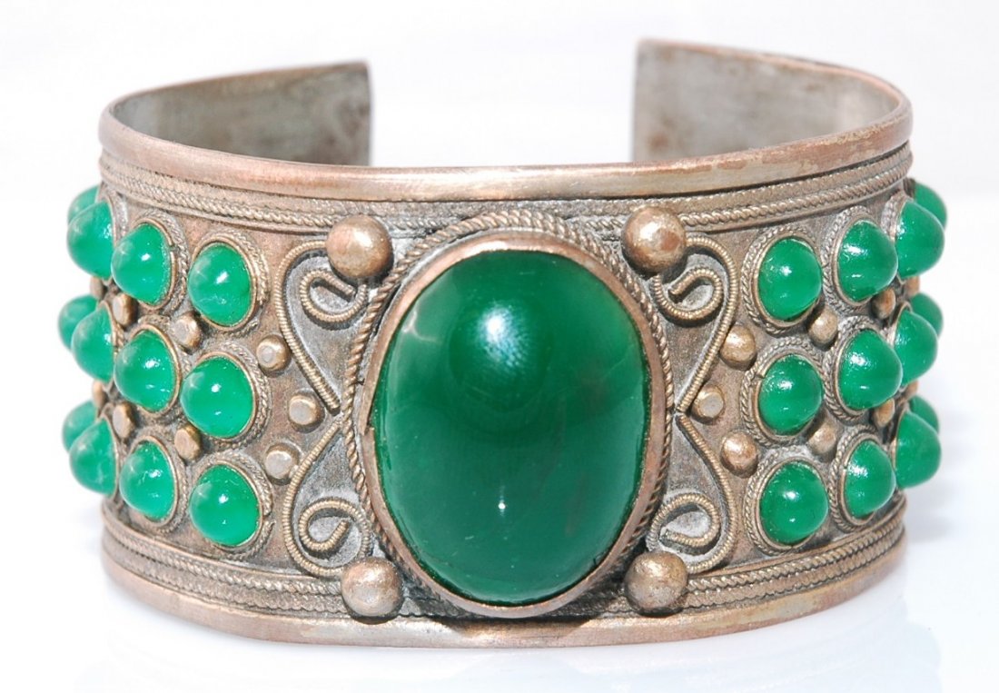 Antique Chinese Burma Jade Bangle: Antique Chinese Burma Jade Bangle with 1 large center jade stone measuring 1" long x 3/4" wide. Includes and additional 42 smaller jade round stones. It is assemble with copper and silver. Circa 1920 