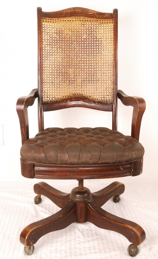 Vintage Executive Chair: Tufted brown leather seat executive chair with rattan mesh backing. Fair condition for its age, has rattan mesh backing. H 42" x W 21" x D 19"
