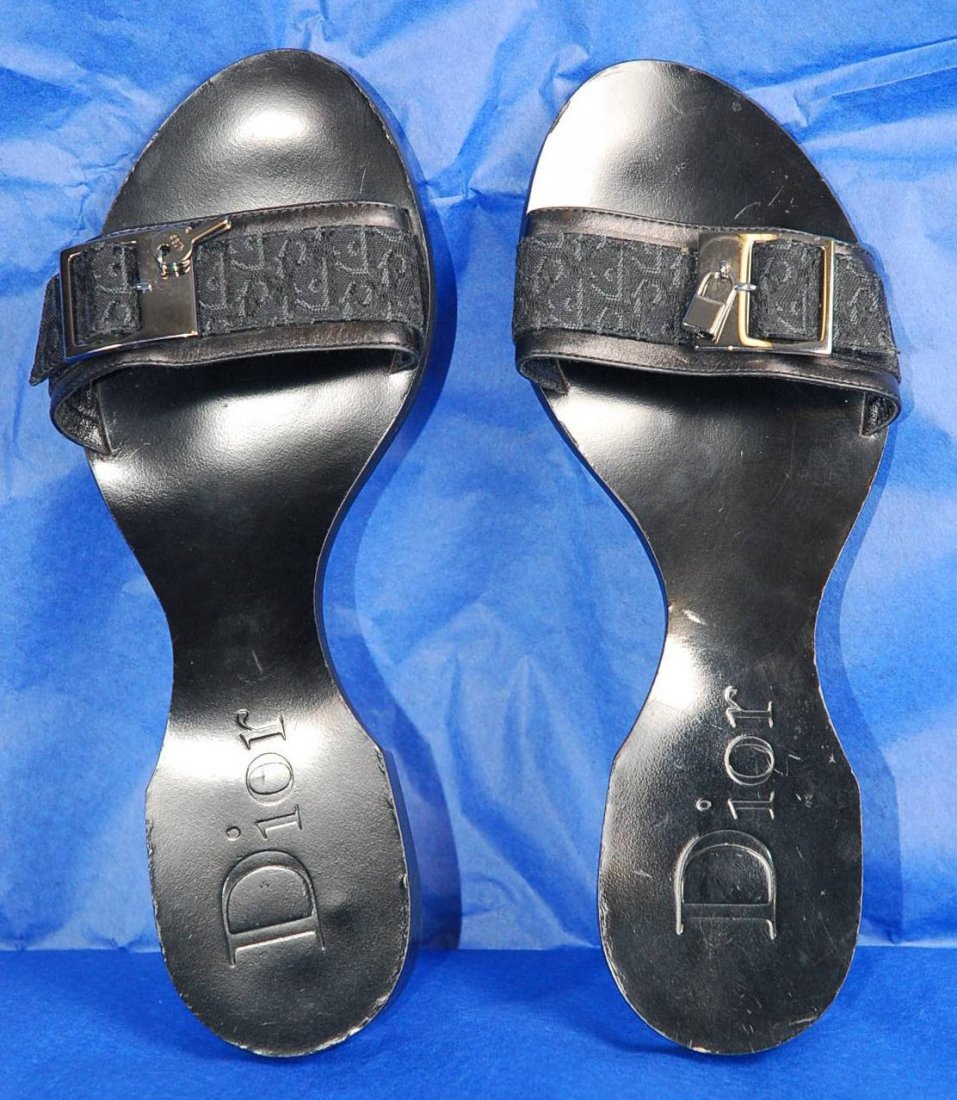 Pair of Christian Dior Leather Ladies Flats: Dior made in Italy slide in sandle has unique sole shape. Black leather size 37. Has the Dior logo print with pewter colored buckle. Left shoe buckle with pewter keys, right shoe with pewter lock. Use