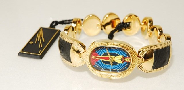 Erte Limited Edition "Salome" Art Deco Watch: Watch features Erte's design of "Salome" on it's face. The band has links of black leather inserts surrounded by textured gold edging. There is a dark black stone at the end of the stem. This particul