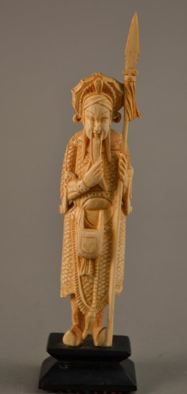 Ivory Warrior: carved ivory warrior with a spear, with great attention to detail on a wood stand. 8" tall