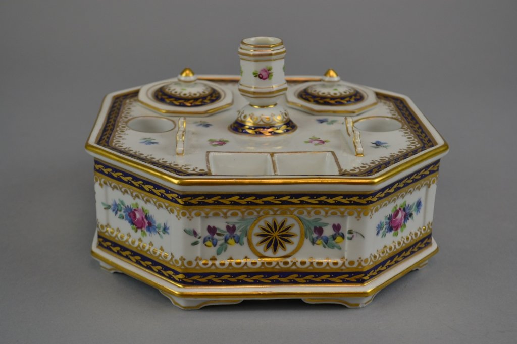 A Sevres Style Porcelain Ink Stand Of octagonal form,: Of octagonal form, having gilt painted and enameled floral details throughout, comprising two removable covered wells, integral candle holder, stamp receptacles, and pen tray, the interior with apocry