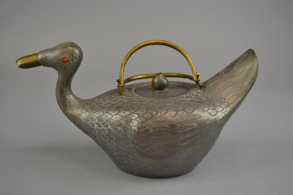 A Chinese Figural Pewter Teapot Depicting a duck,: Depicting a duck, having incised decoration throughout and inlaid semi-precious stone accents and cover finial. Size: 5 1/4" height x 9 1/2" length