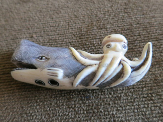 IVORY WHALE AND OCTOPUS SCRIMSHAW, 1.5 INCHES: IVORY SCRIMSHAW OF WHALE WITH OCTOPUS, BEAUTIFULLY CARVED IVORY WITH DARKEN AREAS. APPROX 1.5 INCH LONG