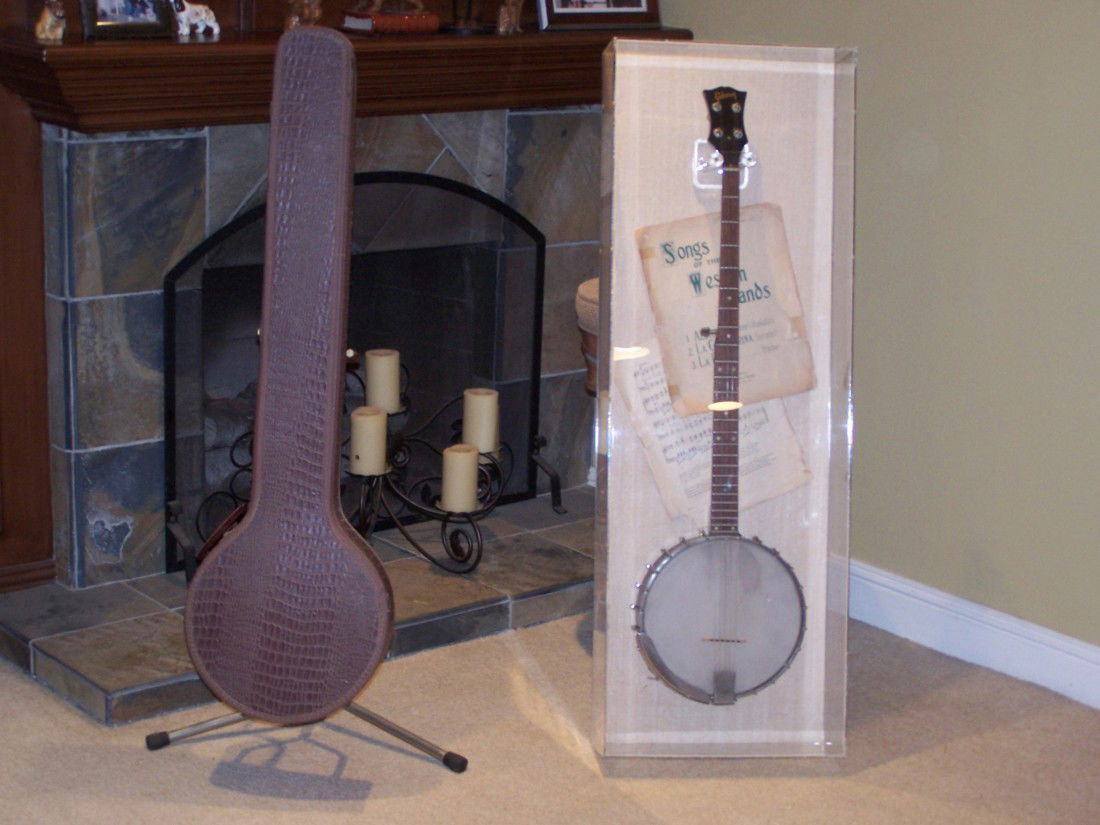 1965 LONGNECK GIBSON BANJO RB-180: 1965 LONGNECK GIBSON BANJO RB-180, SERIAL #154094. TWENTY HOLE TONE RING. SINGLE ROD, OPEN BACK MODEL. WITH LITTLE FRET WEAR AND NICE STRAIGHT NECK. COMES WITH BANJO CASE AND COMES WITH CUSTOM CLEAR C