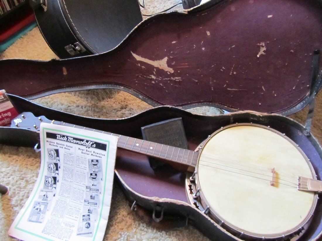VINTAGE 4 STRING TENOR BANJO IN CASE: VINTAGE 4 STRING BANJO IN CASE, THE BACK OF THE HEAD IS WOODEN WITH A DESIGN, COMES WITH CASE, LE BELLA AND BLACK DIAMOND STRINGS, AND A NICK MANOLOFF'S TENOR BANJO METHOD BOOK APPROX. 31 INCHES LONG 