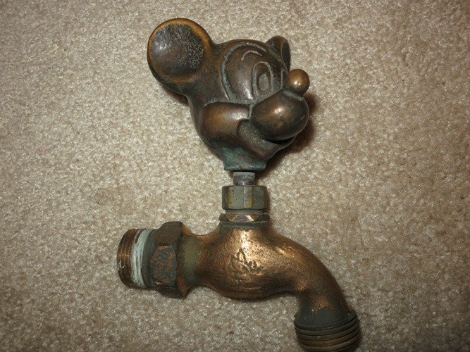 MICKEY MOUSE BRONZE FAUCET, WHITE SWAN: MICKEY MOUSE SOLID BRONZE OUTDOOR FAUCET MADE AND STAMPED BY WHITE SWAN. A RARE COLLECTIBLE FOR DISNEY LOVERS. THIS ITEM IS HARD TO FIND. APPROX. 5 INCHES LONG X 2.5 INCHES WIDE.