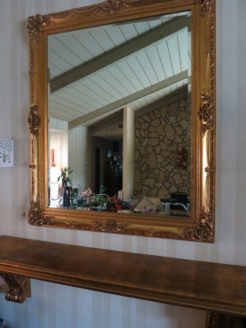 CARVED GOLD GILT WOODEN ENTRY MIRROR & SHELF: CARVED AND WEATHERED GOLD GILT WOODEN ENTRY MIRROR & SHELF ADD AN ELEGANCE TO YOUR HOME. WITH INTRICATELY CARVED SCROLLS AND FLOWERS FRAMING THE APRROXIMATE 5 X 5 FOOT MIRROR. BELOW HANGS THE GILT SHE