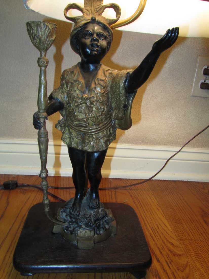 ANTIQUE BLACKAMOOR LAMPS,PAIR: PAIR OF BLACKAMOOR ANTIQUE LAMPS. THIS PAIR OF BLACKAMOOR BOYS WITH THEIR LIGHTING TORCHES ARE CAST FROM BRONZE WITH THE TRADITIONAL LIGHT, GOLD TONE CLOTHES OVER BLACK. THEY ARE ON A DARK WOODEN BASE