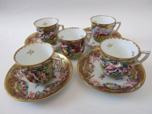 CAPODIMONTE, HALLMARKED, 5 TEA CUP & 4 SAUCER SET: CAPODIMONTE, HALLMARKED WITH THE 1782-1824 CROWN AND "N", ALSO STAMPED WITH A CROWN WITH CROSS, AND NUMBERED. SET OF 5 TEA CUPS & 4 SAUCERS. DESIGNED WITH THE SIGNATURE CAPODIMONTE NUDES AND CHERUBS R