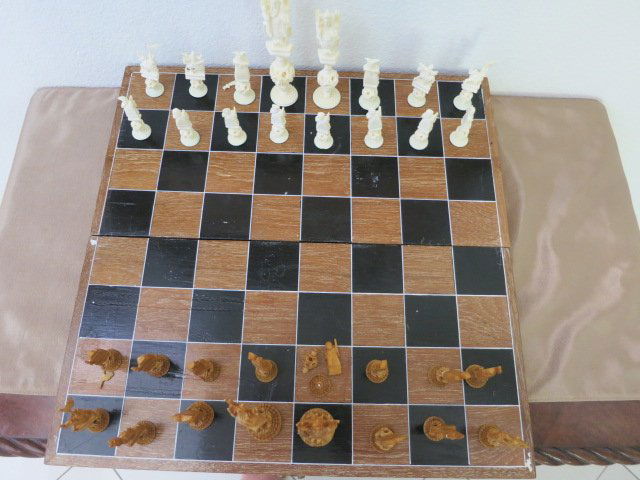 ORIENTAL HAND CARVED CHESS SET: Chinese hand carved wood & ivory chess set consisting of 32 pieces and having fitted wooden box that converts in to the playing surface. Each piece is meticulously carved and monochromed to depict Emp
