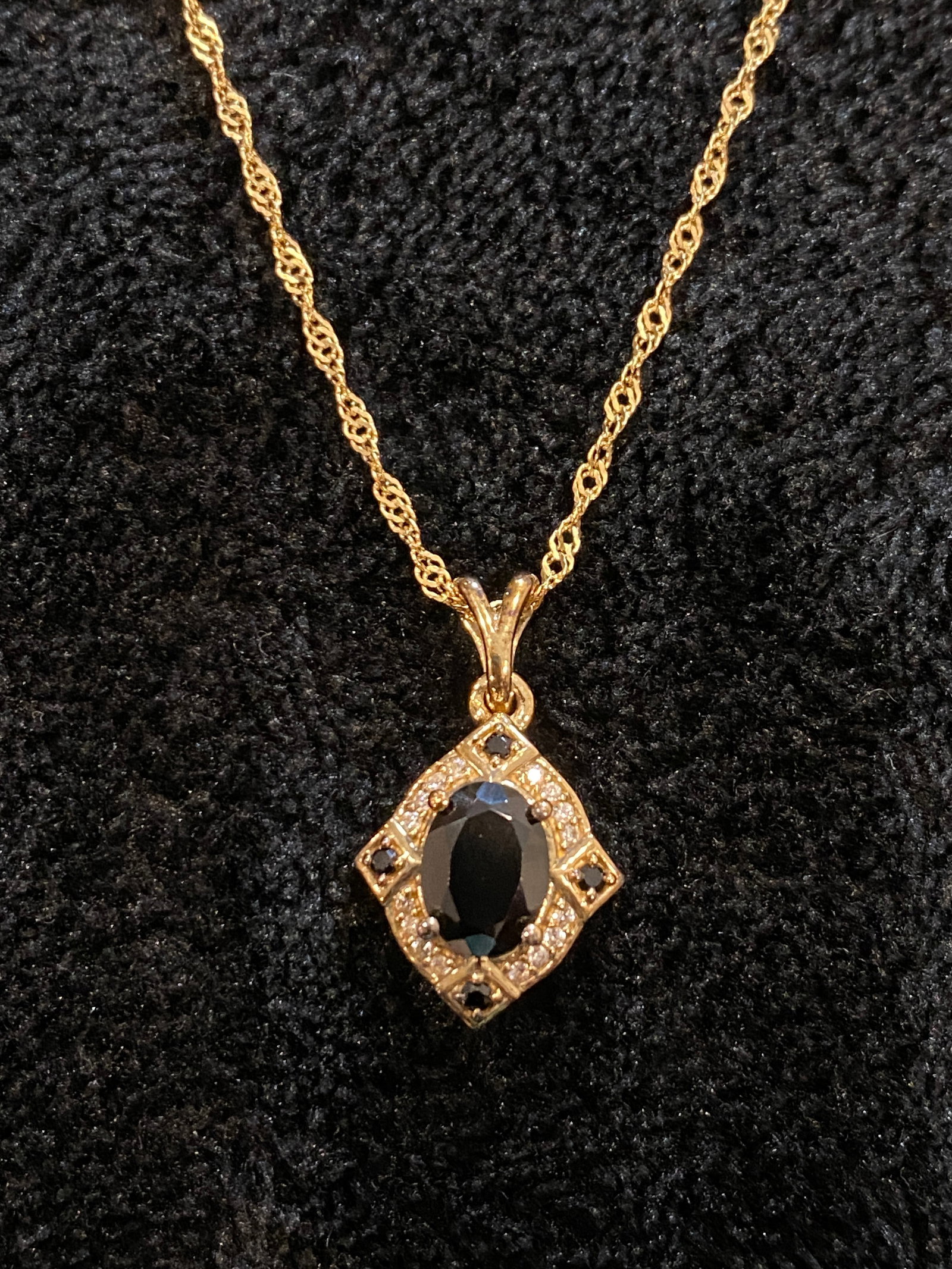 Black Spinel With 0.11ctw White Zircon Yellow Gold tone Over Silver Pendant With Chain: 1.32ct Oval With 0.07ctw Round Black Spinel With 0.11ctw Round White Zircon Yellow Gold tone Over Silver Pendant with 20" Chain. Measures Approximately 0.87"L X 0.51"W. 3mm Bail. Lobster Claw Clasp Wi