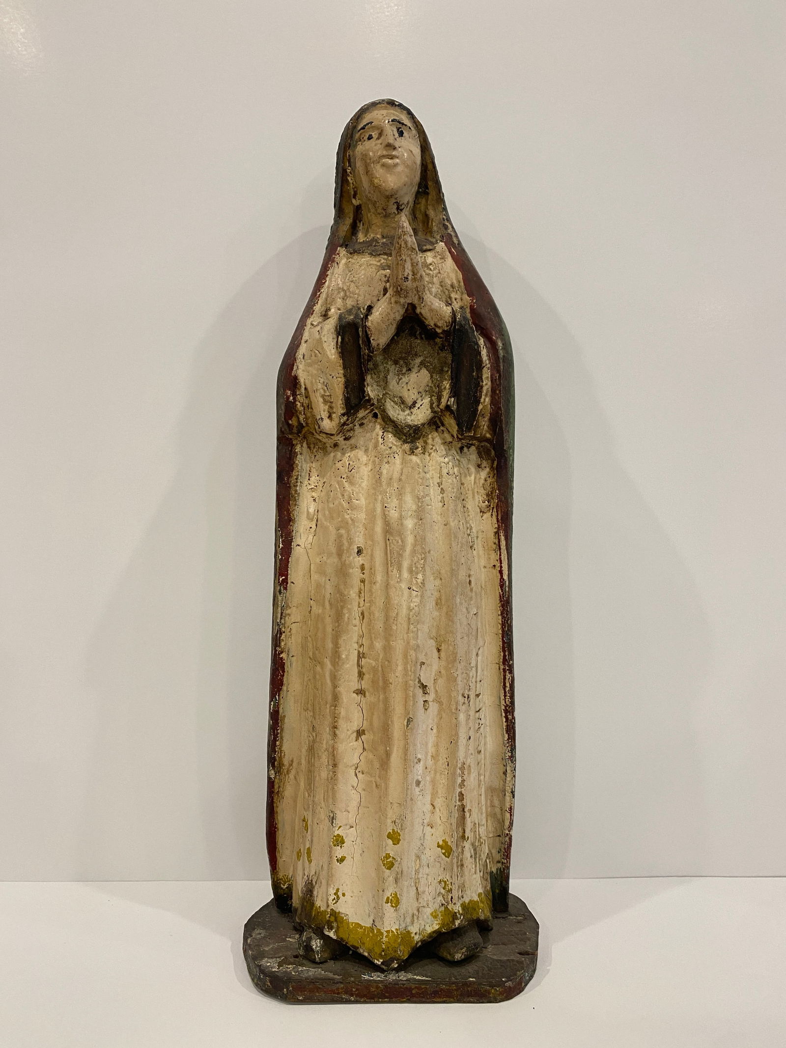 Painted Praying Madonna Sculpture: Shipping from Austin, TX. Dimensions: 17 x 6 in Presenting a serene depiction of piety, this Madonna statue, with hands devoutly clasped, has a lovely rustic charm while the remaining paint hints at i
