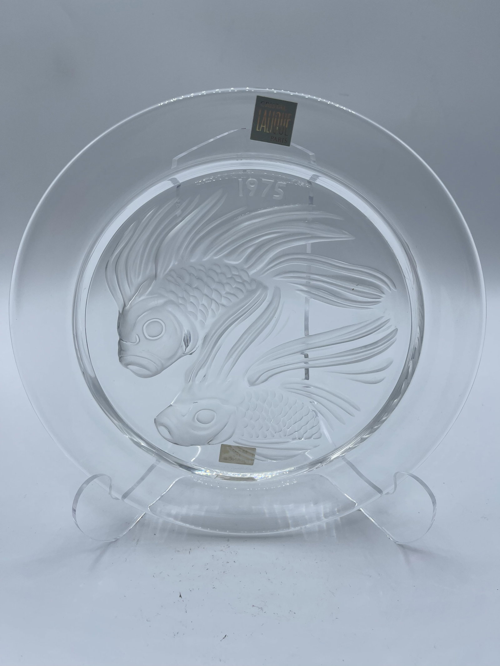 Lalique Duo De Poisson Fish Plate 1975: Lalique Duo De Poisson Fish Plate 1976, comes with stand Lalique is a French luxury glassmaker, established in 1888 by famed glassmaker and jeweler Rene Lalique. The brand gained prominence in the ear