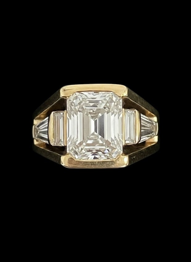 4 Karat Emerald-Cut Diamond Ring in 18k Yellow Gold: Important Three-Stone Emerald-Cut Diamond Ring A sophisticated and substantial three-stone ring, centered by a commanding 4-carat emerald-cut diamond. This centerpiece exhi