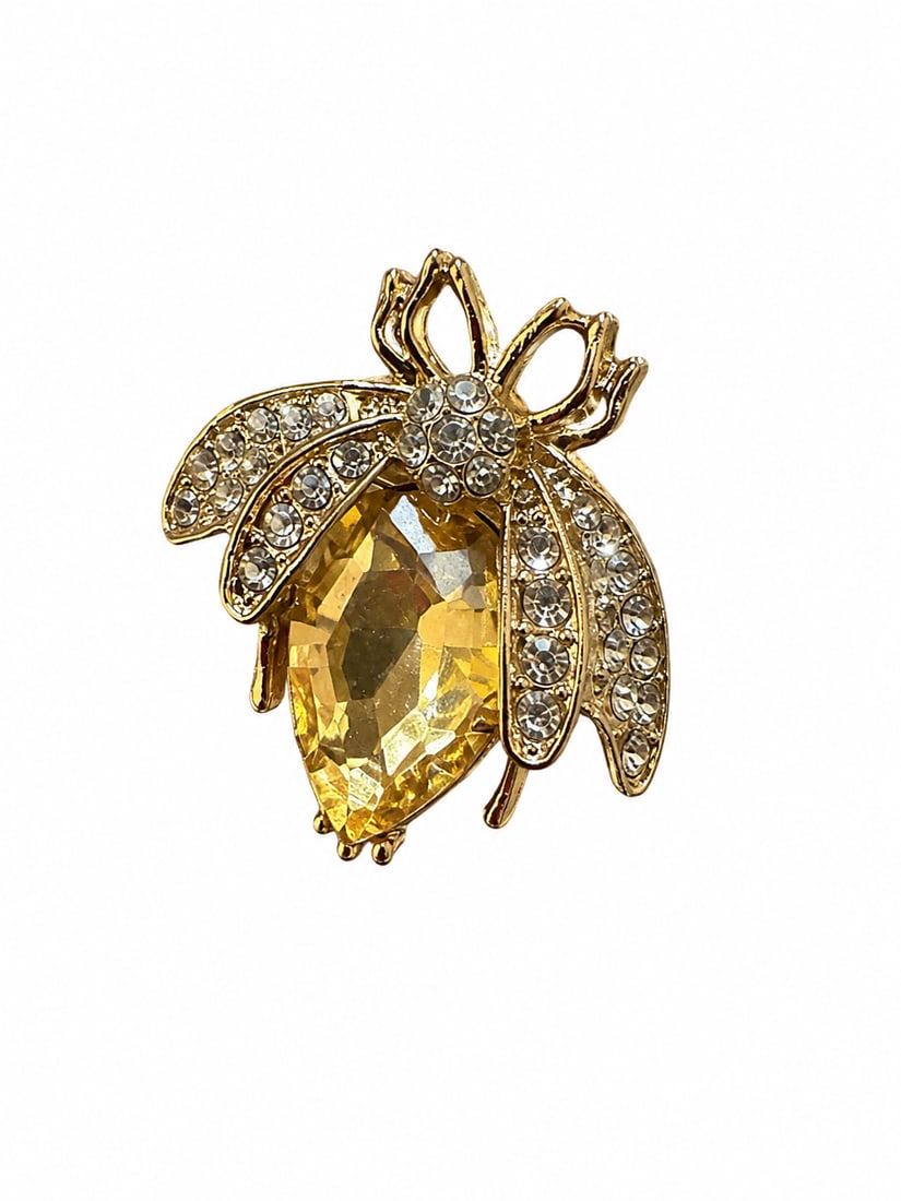 Gold-Tone Yellow & Clear Stone Bee Brooch: Bee-form brooch featuring a large faceted yellow center stone with round clear stone accents throughout the wings and body with pin-back closure.Ships from Newport Beach, CA.Proceeds go to Hoag Hospit