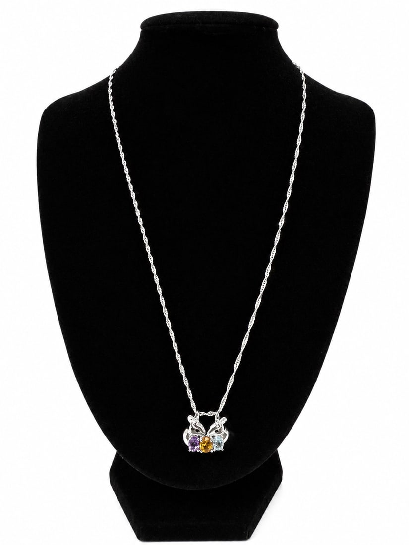 Silver Bunny Pendant Necklace with Multicolor Gemstone Accents: Silver necklace featuring a decorative pendant accented with three colorful faceted stones in purple, golden yellow, and light blue tones. Ships from Newport Beach, CA.Proceeds go to Hoag Hospital Cha