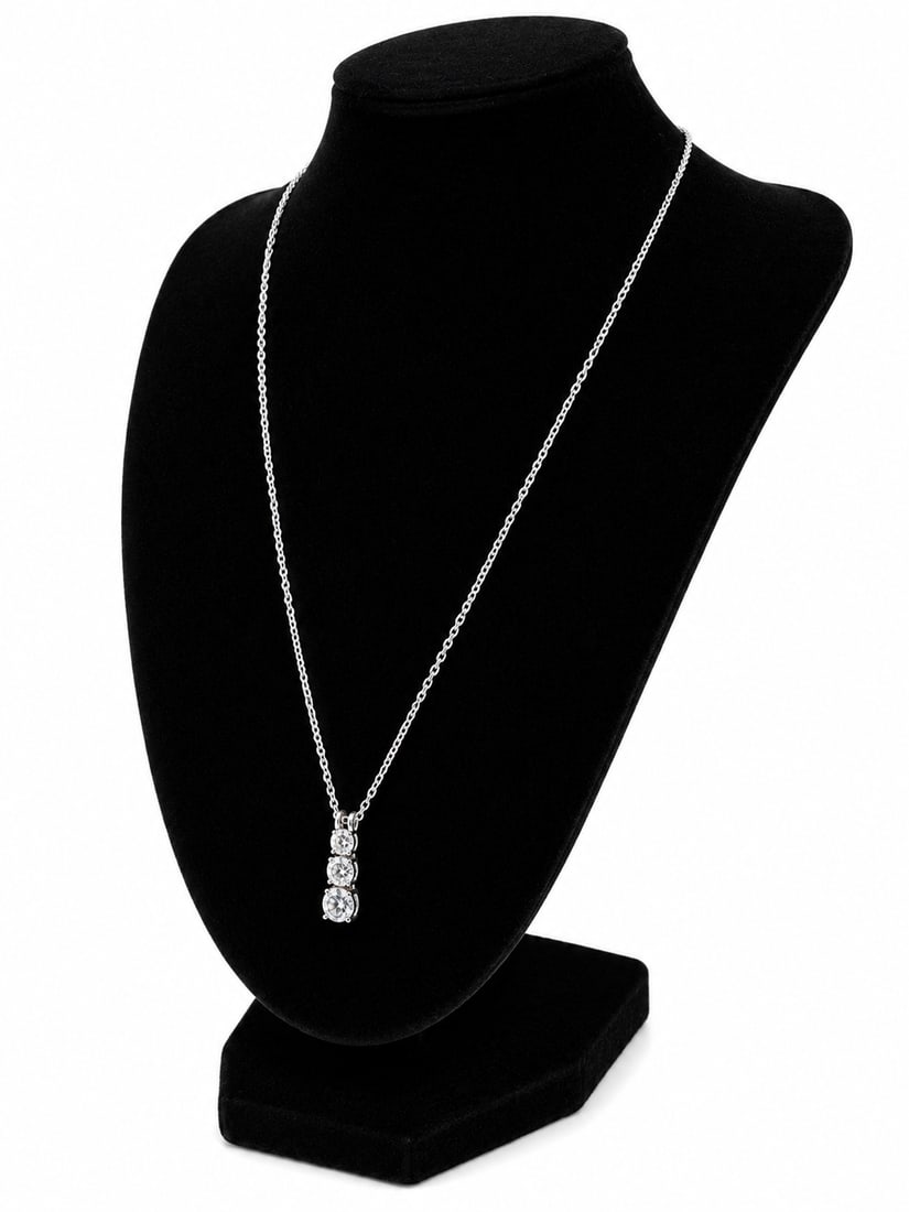 Silver Necklace with Three-Stone Cubic Zirconia Drop Pendant: Silver necklace featuring a vertical drop pendant set with three round clear cubic zirconia stones in graduated settings. Ships from Newport Beach, CA.Proceeds go to Hoag Hospital Charitable Foundatio