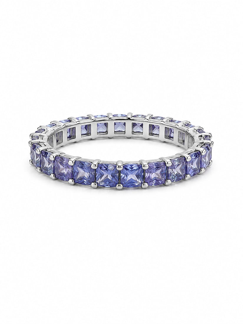 Silver Eternity Ring with Tanzanite Princess Cut Stones: Silver eternity-style ring featuring a continuous row of square princess-cut violet-blue stones with a tanzanite-like appearance, individually prong-set around the band. Ring size 9. Ships from