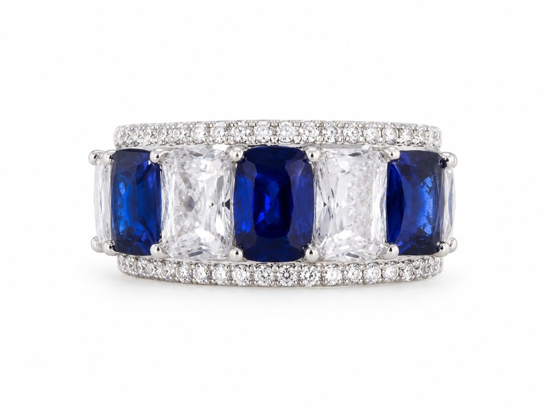 Silver Ring with Sapphire Cushion Stones, Moissanite Clear Stones & Cubic Zirconia Accents: Silver ring featuring alternating deep blue cushion-cut stones with a sapphire appearance and clear cushion-cut stones with a moissanite appearance. Rows of smaller clear cubic zirconia accents frame