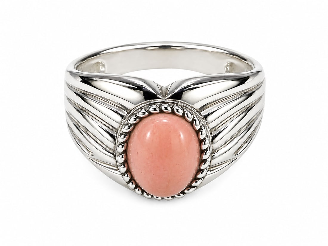 Sterling Ring with Pink Opal Oval Cabochon: Sterling silver ring featuring a smooth oval pink cabochon with an opal appearance, framed by rope-style detailing. The shoulders feature sculpted wing-inspired detailing. Stamped “925” for