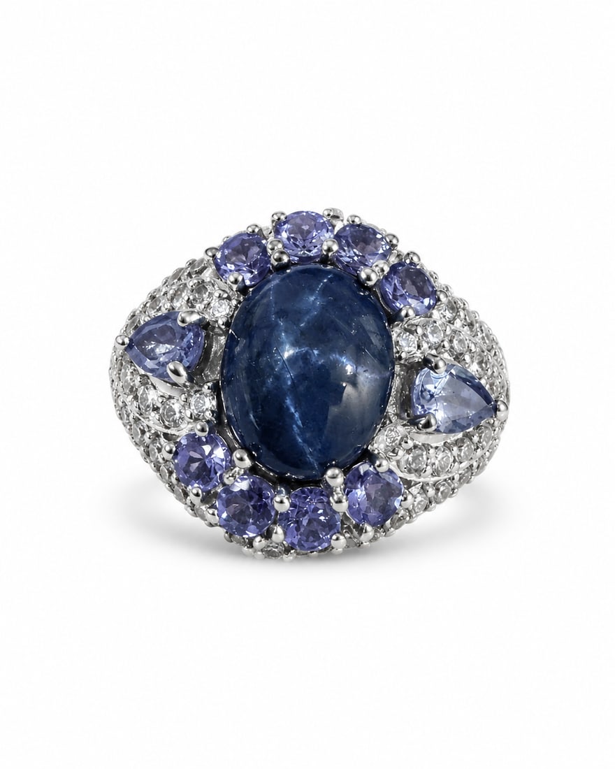 Sterling Silver Blue Sapphire & Tanzanite-Like Multi-Stone Statement Ring: 925 sterling silver statement ring featuring a large oval deep-blue sapphire center stone surrounded by an ornate arrangement of violet-blue tanzanite stones and smaller clear accent stones. The