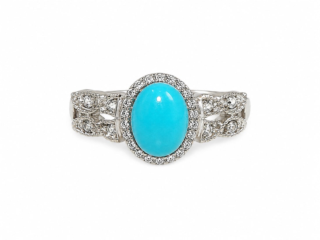 Sterling Turquoise & Clear Stone Halo Statement Ring: 925 sterling silver statement ring featuring a large oval turquoise center stone surrounded by a halo of round clear stones. The ornate openwork band features additional clear stone accents with detai