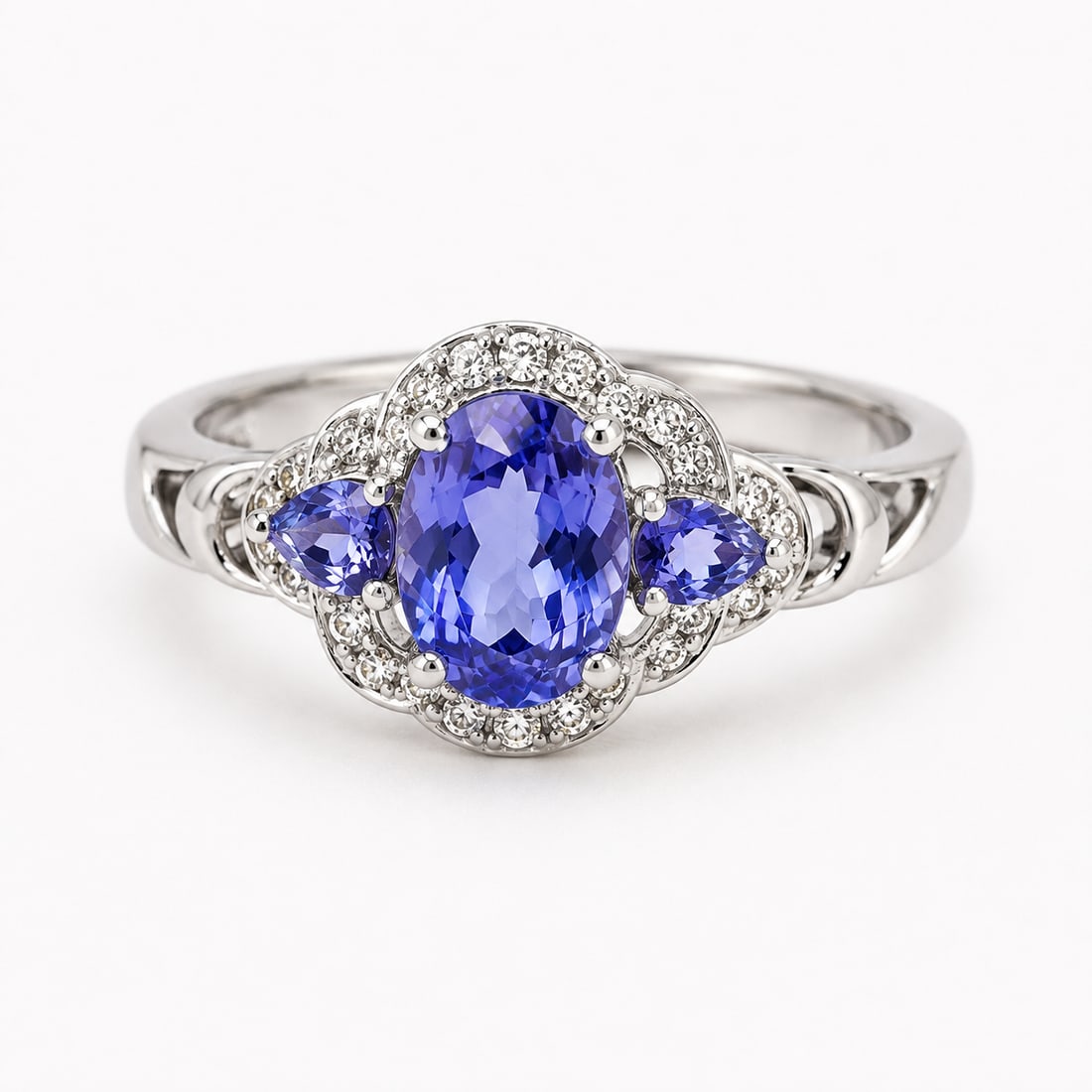 Tanzanite & Crystal Halo 925 Silver Ring: 925-marked silver ring featuring a large oval-cut tanzanite center stone flanked by pear-cut tanzanite stones. The centerpiece is surrounded by sparkling crystal accents in an elegant floral-inspired