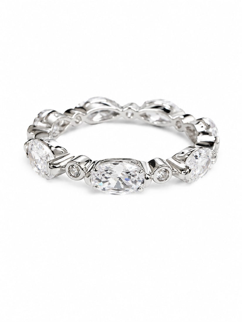 Oval Crystal Eternity Band Ring: Silver ring featuring alternating oval-cut crystals and smaller round crystal accents in a continuous eternity-style design. The repeating oval settings create a polished, elegant pattern around the b