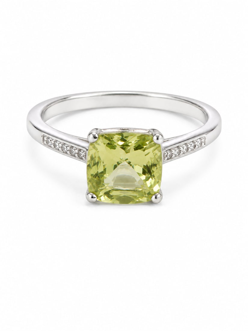 Peridot & White Crystal Sterling Silver Ring: Sterling silver ring featuring a cushion-cut peridot center stone in a four-prong setting. The shoulders are accented with rows of round white crystals for added brilliance. Marked 925. Ring Size: 8