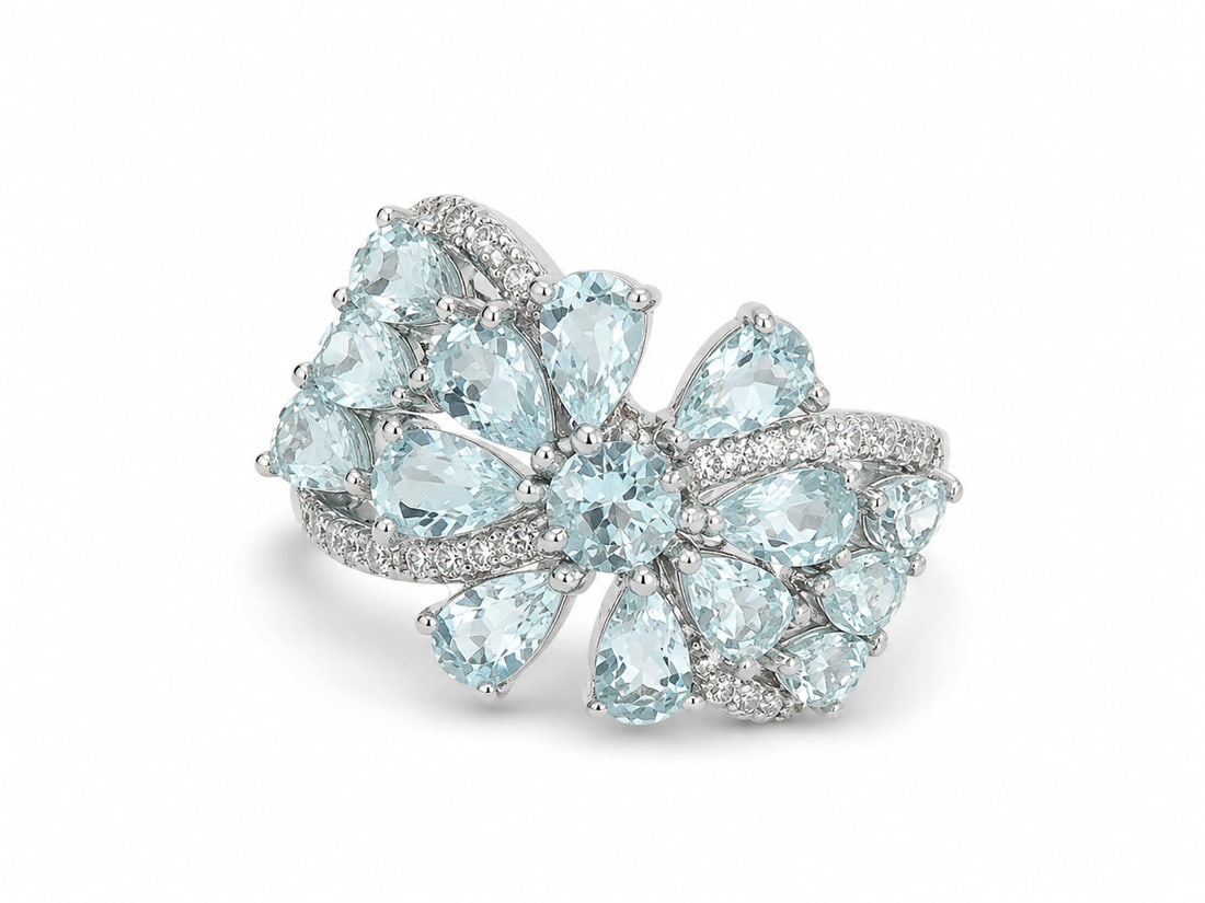 Aquamarine Floral Cluster 925 Sterling Silver Ring: Sterling silver ring featuring an elaborate floral arrangement of pale blue aquamarine gemstones in pear and round cuts. Sweeping rows of sparkling CZ accents weave through the floral design for an