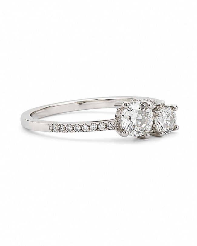 Silver Three Stone Ring with Moissanite Clear Stones & Cubic Zirconia Accents: Silver ring featuring three round clear center stones with a moissanite appearance, accented by smaller clear cubic zirconia stones along the band.Ships from Newport Beach, CA. Proceeds go to Hoag