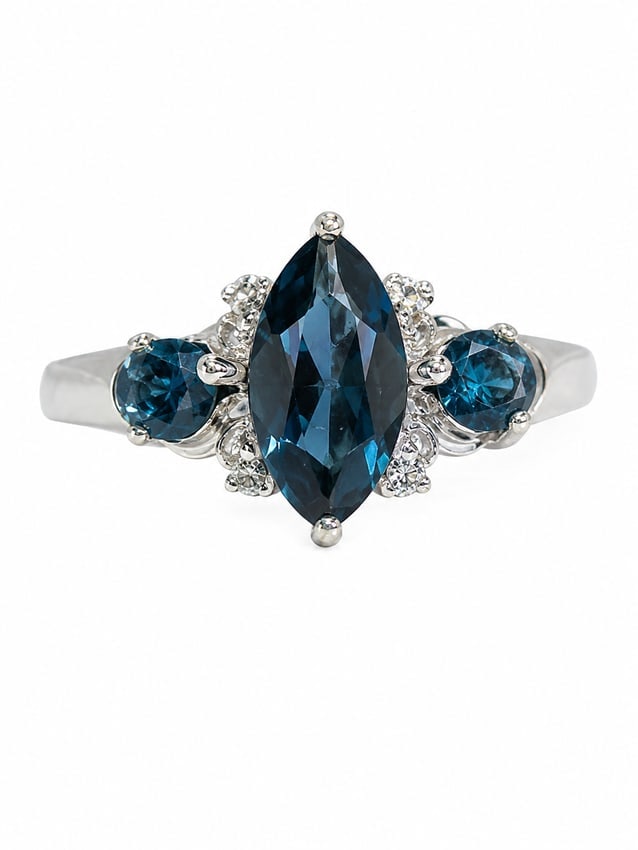 Blue Topaz & White Stone 925 Silver Three-Stone Ring: 925 silver ring featuring a large marquise-cut deep blue topaz center stone, flanked by two round-cut blue topaz stones and smaller white stone accents. The three stone arrangement creates an elegant,