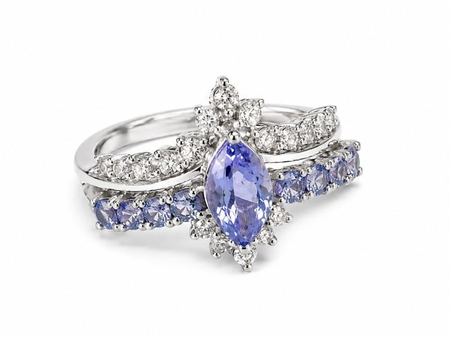 Tanzanite Marquise 925 Sterling Silver Statement Ring: Sterling silver ring featuring a striking marquise-cut tanzanite center stone surrounded by sparkling white CZ accents. Additional violet-blue tanzanite stones sweep across the lower band, while the u