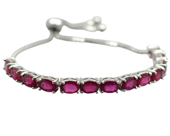Adjustable Ruby Bolo Bracelet in .925 Sterling Silver: Adjustable Ruby Bolo Bracelet A stunning .925 sterling silver bracelet featuring radiant red rubies and a convenient, tie-adjustable bolo closure. Perfect for July birthdays.