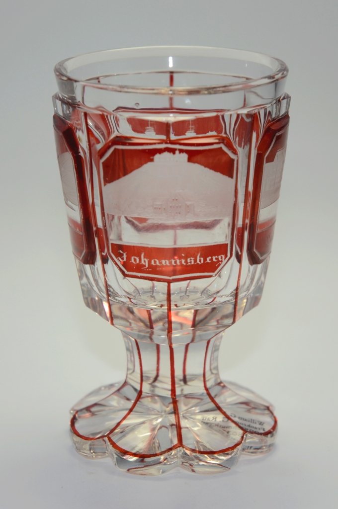 Spa Beaker: Clear glass ruby stained, facet and wheel-cut. Four panels with engraved building scenes. 4.3"ht., Bohemian, circa 1870.