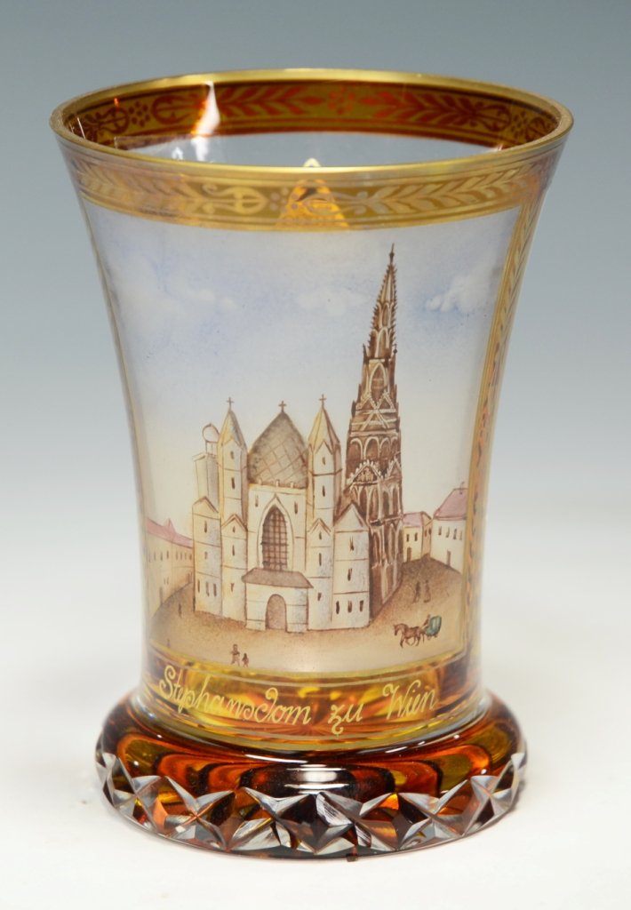 Transparent Enamel Beaker: Blown clear glass amber stained. Diamond-cuts to base. Transparent enamel church and town scene, gilded. 4.75"ht., Signed G.E. Contemporary done in the biedermeier style. Paper label, "Oertel"